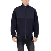 Armani Exchange Blazer bleu homme à fermeture éclair longue et poches avant, avec empiècements bicolores bleu marine et style veste de survêtement zippée.