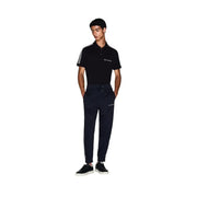 Polo noir à rayures blanches sur les manches et logo brodé, associé à Armani Exchange pantalon bleu en polyester pour homme