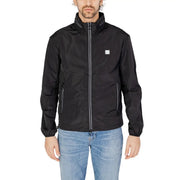 Men’s black lightweight zip blazer with front pockets paired with light wash blue jeans
