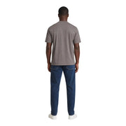 Un homme portant un Armani Exchange T-shirt en coton marron pour homme, porté avec un jean bleu foncé
