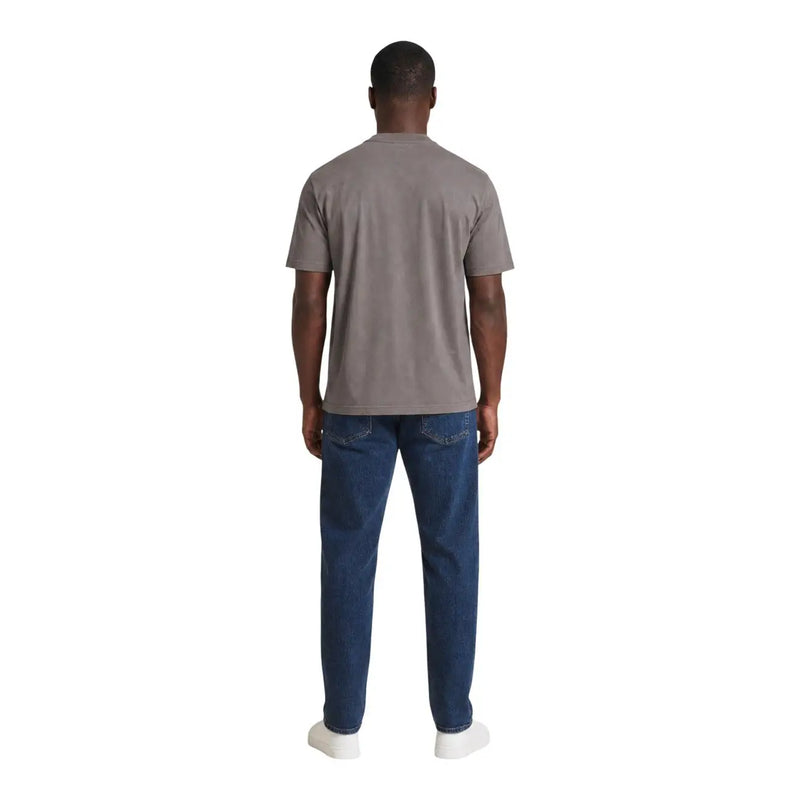 Un homme portant un Armani Exchange T-shirt en coton marron pour homme, porté avec un jean bleu foncé
