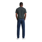 Jean en denim bleu foncé à cinq poches et délavage subtil aux cuisses, associé à Armani Exchange T-shirt en coton vert pour homme