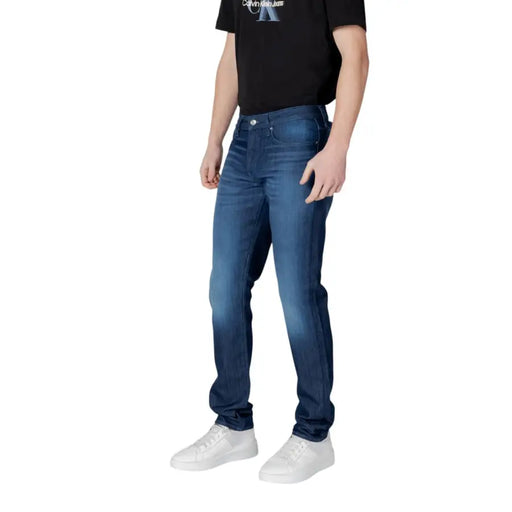 Armani Exchange Jean homme en coton stretch bleu foncé, coupe slim, délavage délavé et surpiqûres classiques.