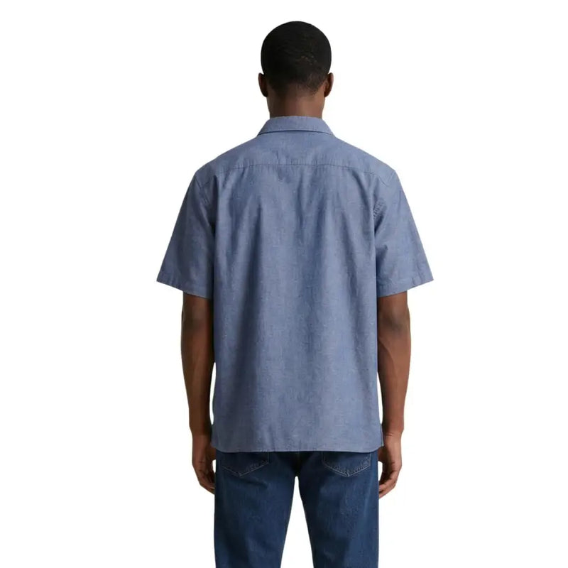 Armani Exchange Chemise homme en chambray bleu clair, manches courtes, col classique et coutures soignées.