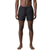 Armani Exchange men swimwear featuring black swim trunks with a subtle light gray interlocking letter pattern