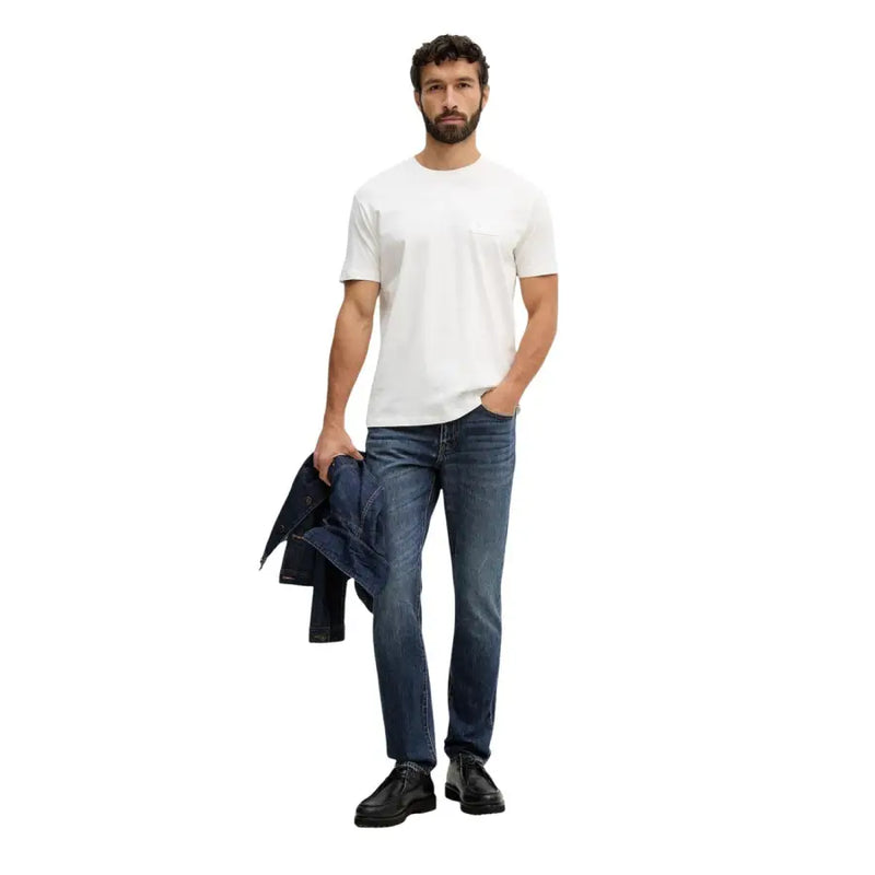 Armani Exchange hommes t-shirt T-shirt blanc à col rond et poche poitrine unique, porté avec un jean brut.