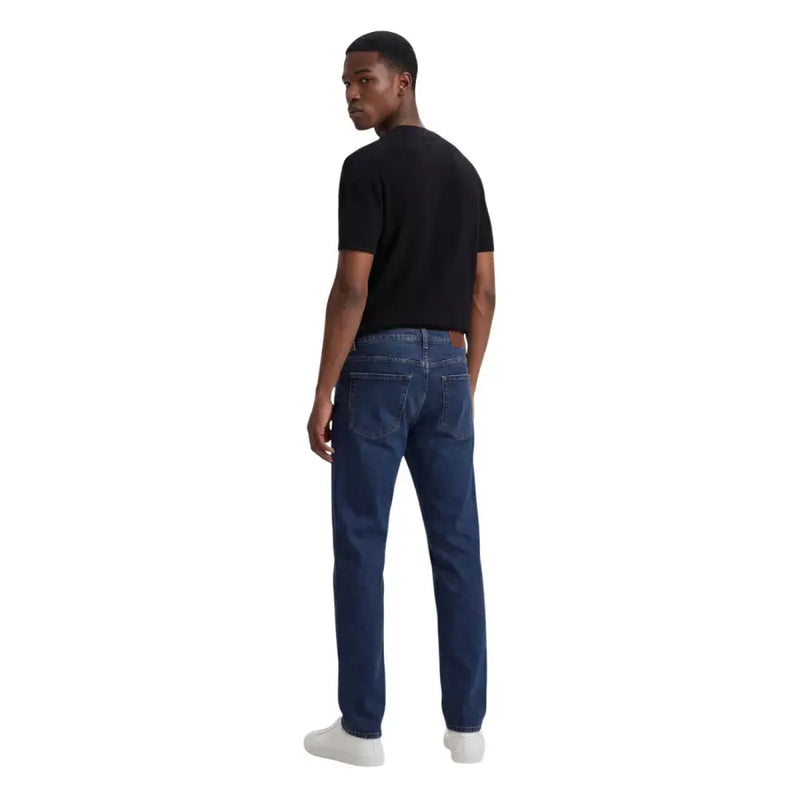 Jean en denim bleu foncé avec une coupe classique à cinq poches et un délavage subtil aux cuisses. armani exchange image du produit t-shirt homme