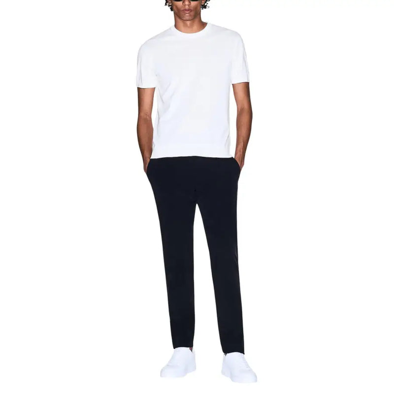 Armani Exchange hommes t-shirt Associé à un pantalon noir élégant, confectionné dans un tissu lisse et aux lignes épurées.