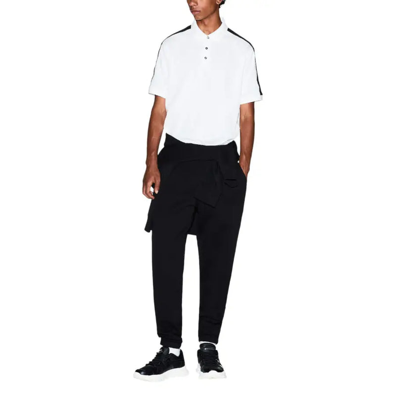 Polo blanc avec bordures noires au col et aux manches, porté avec Armani Exchange pantalon pour homme dans une tenue décontractée
