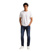 Un homme portant un Armani Exchange T-shirt blanc en coton pour homme, col rond blanc uni, et jean slim bleu foncé