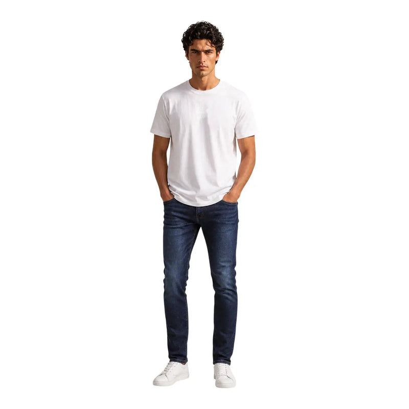Un homme portant un Armani Exchange T-shirt blanc en coton pour homme, col rond blanc uni, et jean slim bleu foncé