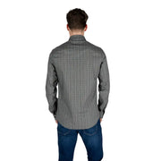 Un homme portant un Armani Exchange Chemise noire à manches longues en coton pour homme, à motif géométrique discret.