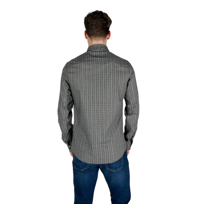 Un homme portant un Armani Exchange Chemise noire à manches longues en coton pour homme, à motif géométrique discret.