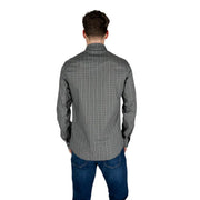 A man wearing an Armani Exchange mens black geometric long sleeve cotton shirt with a subtle patterned design