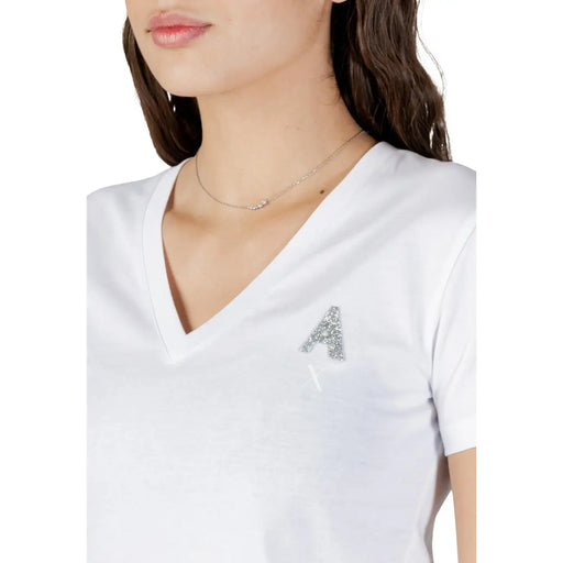 Armani Exchange T-shirt blanc en coton à col en V pour femme, orné d'une lettre A argentée scintillante sur la poitrine.