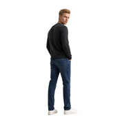 Armani Exchange Pull en laine bleu foncé pour homme, porté avec un jean en denim coupe classique et légèrement délavé, vue de face