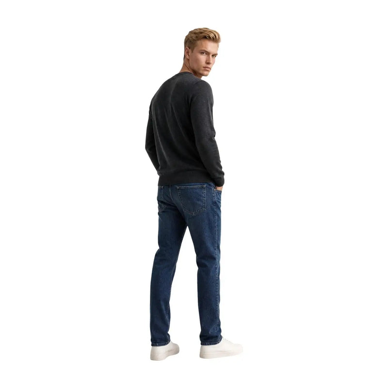 Armani Exchange Pull en laine bleu foncé pour homme, porté avec un jean en denim coupe classique et légèrement délavé, vue de face