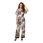 Une femme porte une combinaison Artigli beige en viscose à col en V et imprimé botanique marron, avec une ceinture assortie.