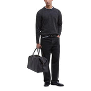 Black leather duffle bag with textured surface and silver hardware