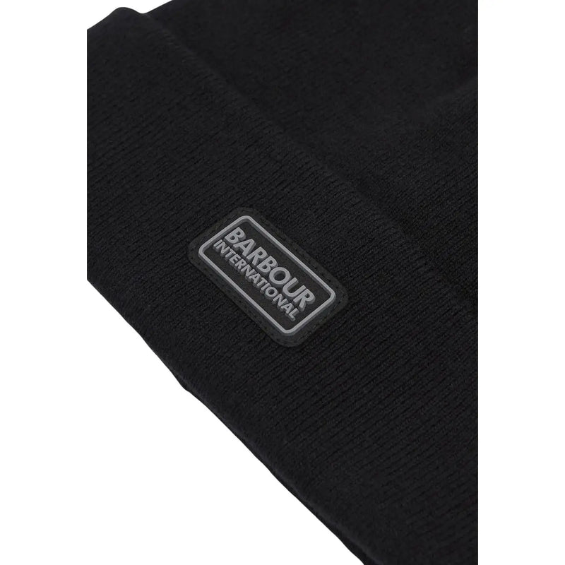 Bonnet Barbour International en laine noire pour homme, avec logo rectangulaire, vue de face