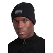 Bonnet Barbour International en laine noire côtelée pour homme, avec logo rectangulaire, vue de face
