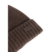 Brown ribbed knit beanie with metal tag detail.