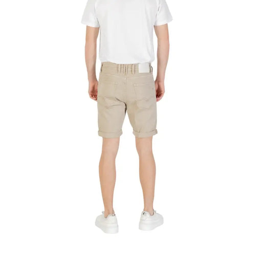 Beige chino shorts paired with white sneakers displayed in a fashion product image