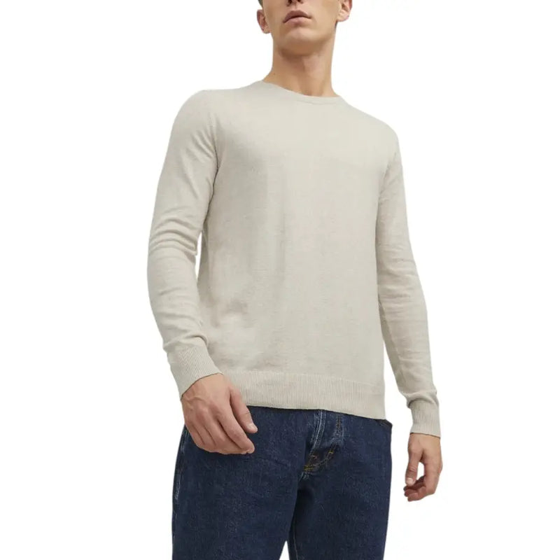 Beige crew-neck sweater paired with dark blue jeans for a casual stylish look