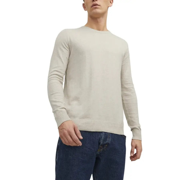 Beige crew-neck sweater paired with dark blue jeans for a casual stylish look