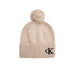 Beige knit beanie with black CK logo and fluffy pompom for stylish warmth