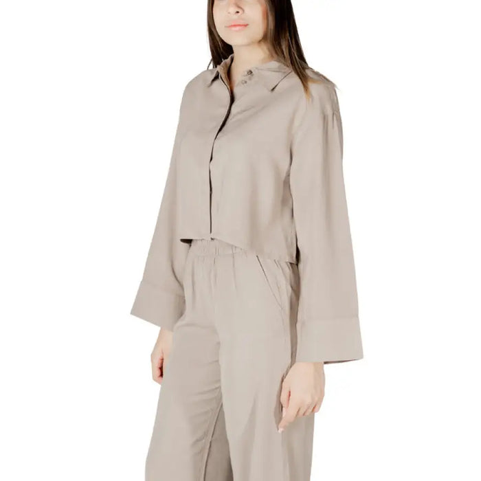 Beige two-piece open back pantsuit displayed in a product image for elegant formal wear