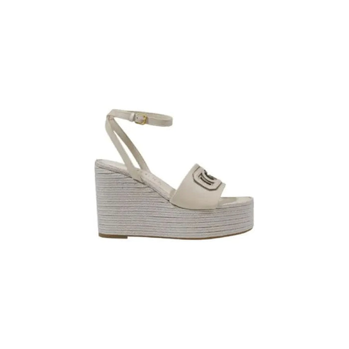 Beige wedge sandal with ankle strap from Guess featuring buckle and bow design