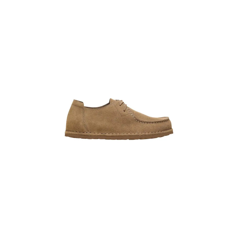 Mocassins Birkenstock pour homme en daim beige, modèle à enfiler en daim beige et détails de lacets cousus.