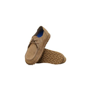 Mocassins Birkenstock pour homme en daim beige, lacés, semelle en caoutchouc texturé et doublure bleue.
