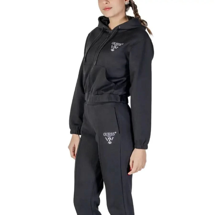 Black athletic tracksuit with cropped hoodie and matching sweatpants featuring Guess logo