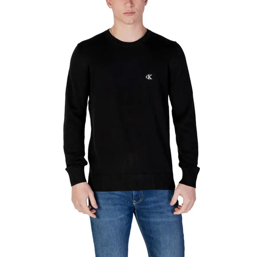 Black Calvin Klein crewneck sweater displayed on a model in a product image