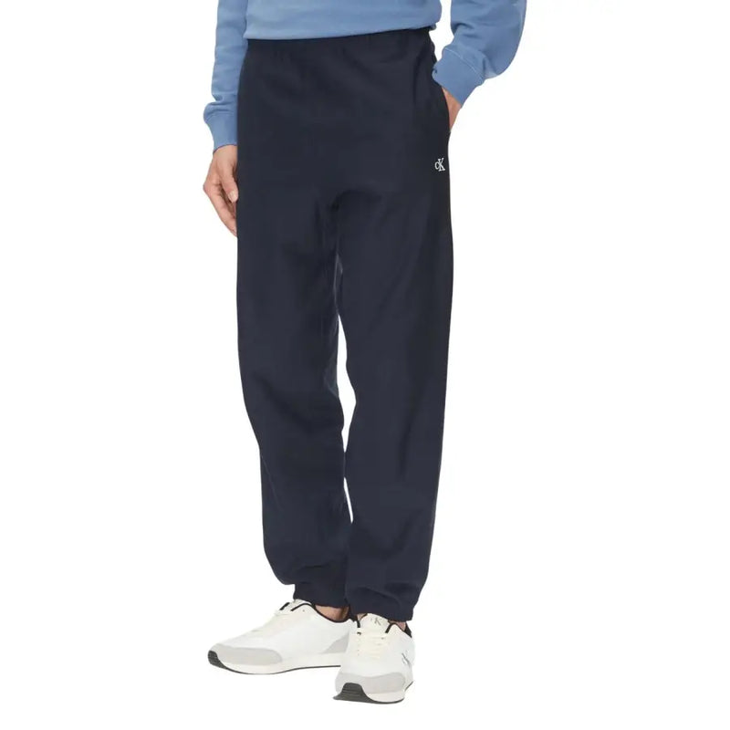Pantalon de survêtement noir Calvin Klein avec ourlets élastiques et bas de pantalon de jogging bleu marine foncé orné d'un logo blanc discret sur la jambe gauche