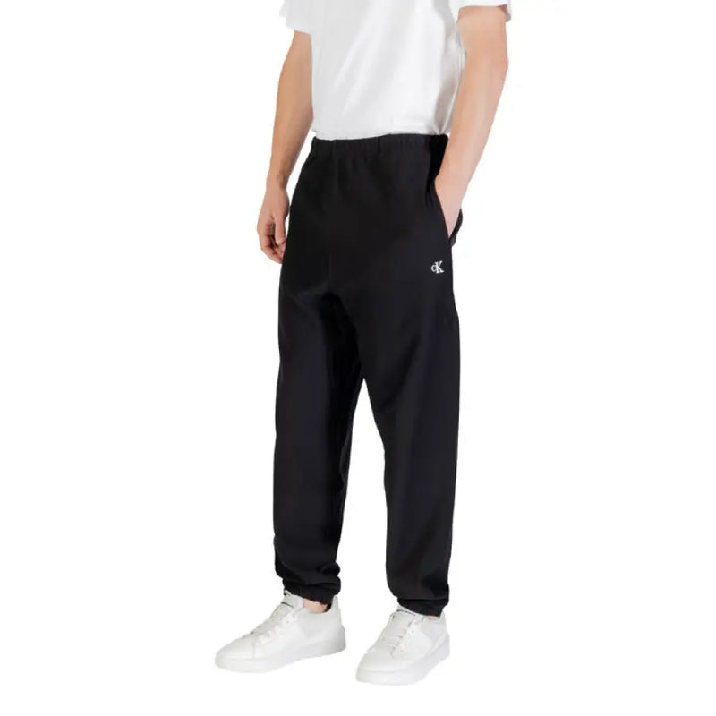 Black Calvin Klein sweatpants with elastic cuffs displayed in a product image