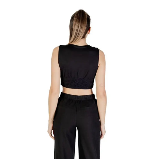 Women in black crop top and pants set showcasing stylish casual wear