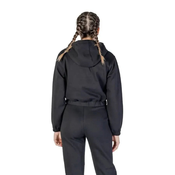 Black hooded sweatshirt by Guess with zips and front pockets, model shown from behind