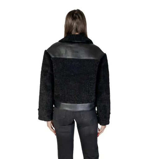 Black faux fur jacket with shearling collar and leather accents for stylish warmth