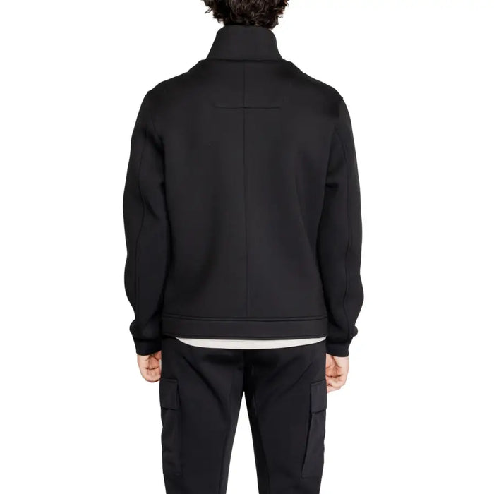 Elegant black button-up jacket and matching pants ensemble on display