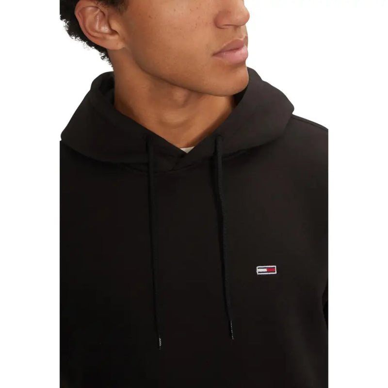Black long hooded Tommy Hilfiger sweatshirt with small embroidered logo and front pockets for fall winter wear