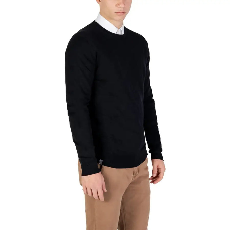Black crew neck sweater with white collar and cuffs, made of cotton.