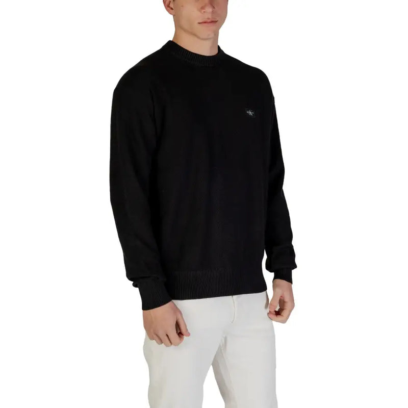 Black long-sleeved crew neck sweater displayed in a product image for fashion apparel