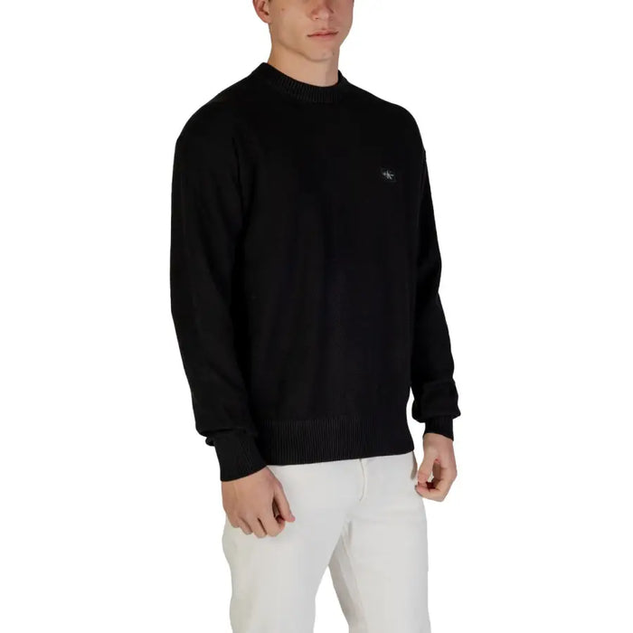 Black long-sleeved crew neck sweater displayed in a product image for fashion apparel