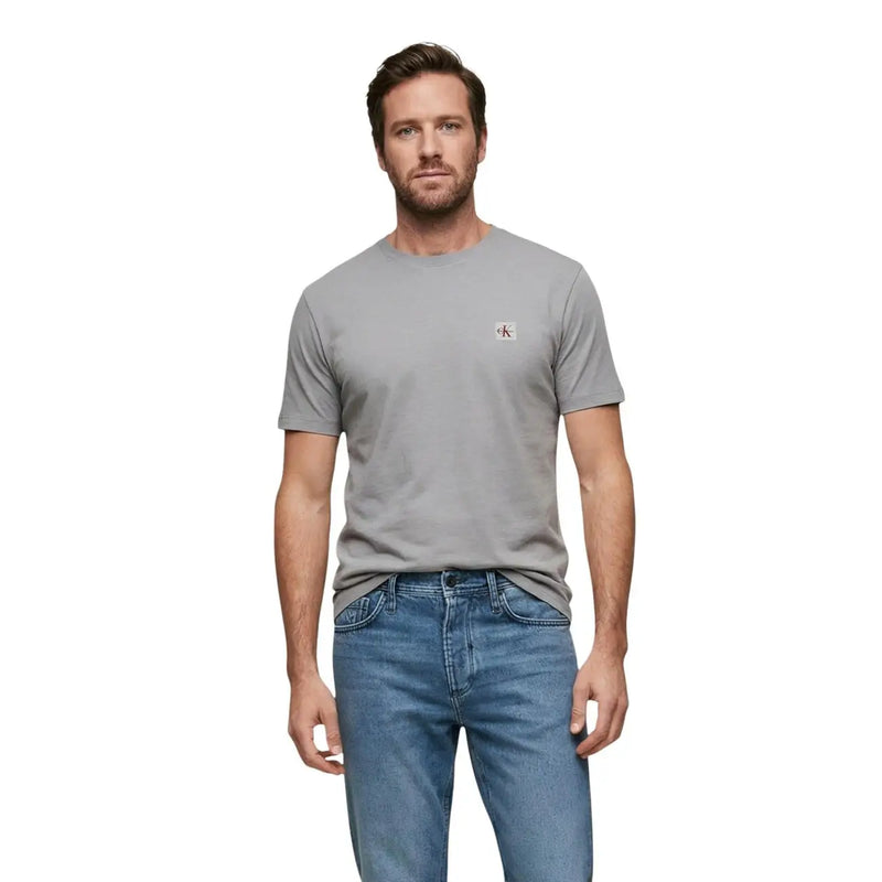 Black short sleeve crewneck t-shirt in gray featuring a small red and white Calvin Klein logo on the left chest