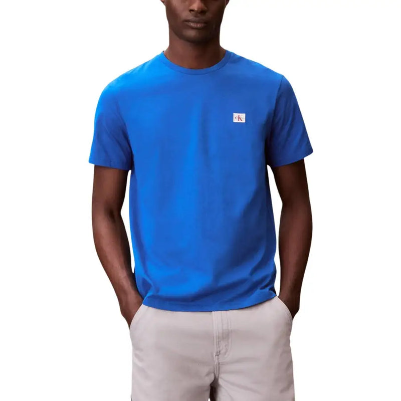 Col rond noir à manches courtes t-shirt avec un bleu vif Calvin Klein Tissu avec un petit écusson blanc portant le logo sur la poitrine gauche