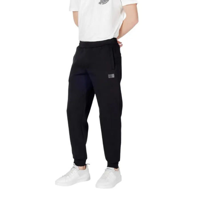 Black sweatpants paired with white sneakers for a casual athletic look