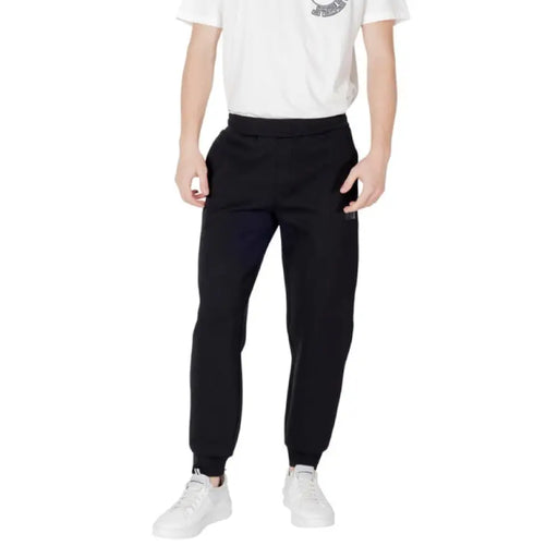 Black sweatpants paired with white sneakers, ideal for casual or athletic wear
